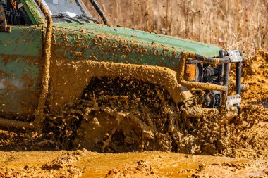 Çamur ve kumla kaplı arazi aracı lastikleri, su ve çamurla geçen araba, off-road aracı Towin.
