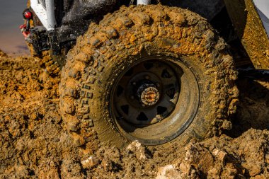 Çamur ve kumla kaplı arazi aracı lastikleri, su ve çamurla geçen araba, off-road aracı Towin.
