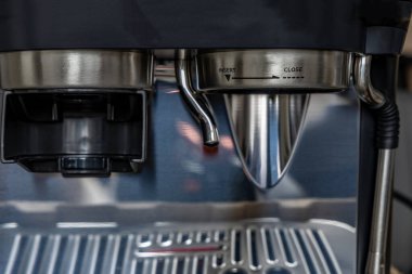 Kahve makinesi, espresso makinesi, fincana yakın çekim ve demleme başlığı.