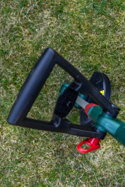 Pille çalışan çim biçme makinesi, bahçeye yerleştirilmiş kablosuz budayıcı, yeni bahçe ekipmanları.