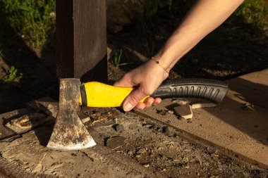 Eldivenli kadın beton zemini baltayla parçalıyor, fayansları temizliyor, döşemeleri söküyor, fayansları terrac 'a seriyor.