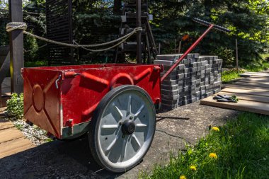 Döşeme taşlarını taşımak için kırmızı tramvay, Bahçe terasına granit kaldırım taşları ve fayanslar döşemek için