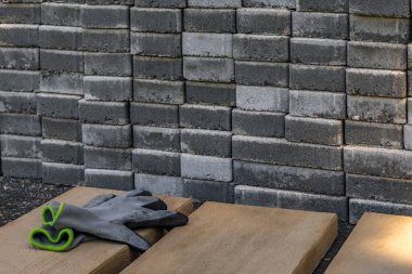 Bahçeye istiflenmiş gri granit küpler, garda verandaya serpiştirilmiş fayanslar ve küpler için hazırlık.