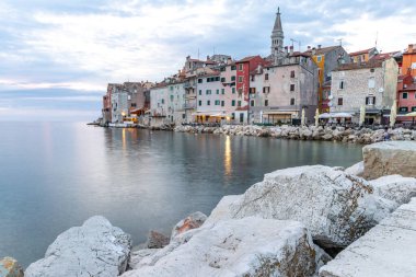 Rovinj 'deki Aziz Euphemia Kilisesi, kıyıya demirlemiş balıkçı tekneleri, Adriyatik Denizi kıyısında yürür