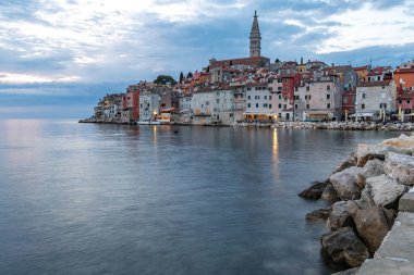 Rovinj 'deki Aziz Euphemia Kilisesi, kıyıya demirlemiş balıkçı tekneleri, Adriyatik Denizi kıyısında yürür