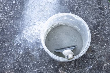 Balkona fayansları, konteynırları ve karıştırıcıyı yapıştırmak için harç ve zamk harcı harmanlıyorum.