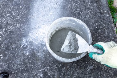 Balkona fayansları, konteynırları ve karıştırıcıyı yapıştırmak için harç ve zamk harcı harmanlıyorum.