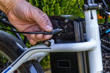 Elektrikli bisikletin pilini şarj etmek için güç kablosu. Yolculuk sırasında motoru şarj etmek için şarj aleti.