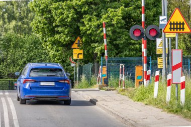 Arabalar kırmızı ışıkta geçen bir demiryolundan geçiyor, kavşaktaki demiryolu engelleri, trafik ihlali...