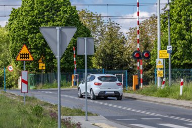 Arabalar kırmızı ışıkta geçen bir demiryolundan geçiyor, kavşaktaki demiryolu engelleri, trafik ihlali...