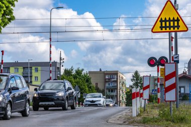 Arabalar kırmızı ışıkta geçen bir demiryolundan geçiyor, kavşaktaki demiryolu engelleri, trafik ihlali...