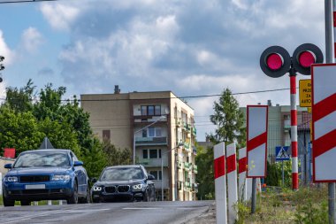 Arabalar kırmızı ışıkta geçen bir demiryolundan geçiyor, kavşaktaki demiryolu engelleri, trafik ihlali...