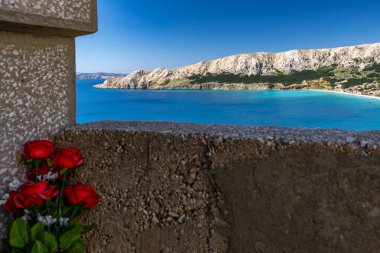 St. John Kilisesi, beyaz haç, çan kulesi, tepedeki mezarlık, KR adasındaki Baska kasabasının manzarası.