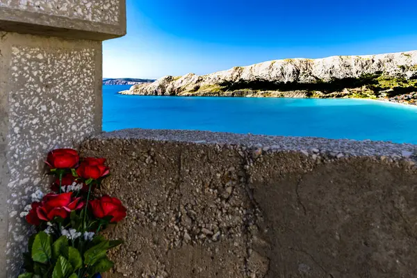 St. John Kilisesi, beyaz haç, çan kulesi, tepedeki mezarlık, KR adasındaki Baska kasabasının manzarası.