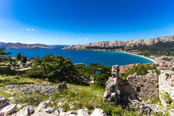 Baska 'dan mezarlığa ve St. John Kilisesi' ne uzanan turistik patika, Baska Kilisesi harabeleri, yukarıdan şehir manzarası, KR adasında plajı olan bir panorama.