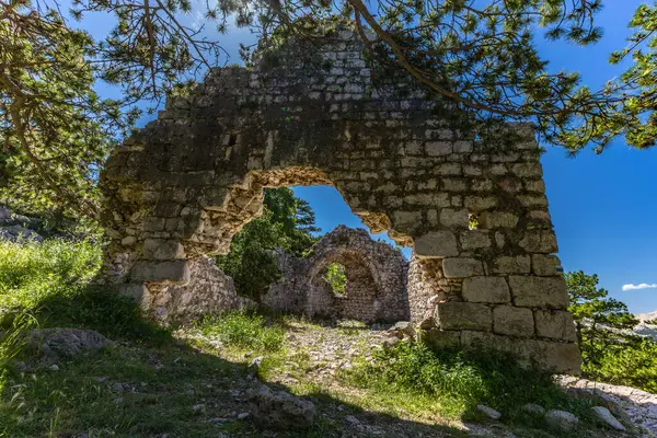 Baska 'daki eski kilisenin kalıntıları, bir tepede, KR' deki Baska kasabasının tepelerinde taş kalıntıları.