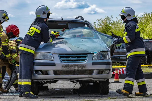 İtfaiyeciler kazaya karışan bir yolcu aracının ön camını kesmek için makas kullanırlar.