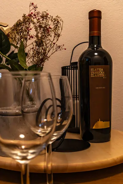 KRK, Zlahtina adasındaki Vrbnik 'te üretilen bir şişe Hırvat şarabı ve masada bir bardak kuru şarap.