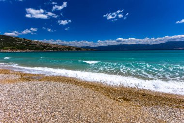 KRK adasındaki Baska 'daki boş çakıl taşı plajı, tatil sezonundan önce Hırvatistan' ın Adriyatik Denizi 'nde masmavi su