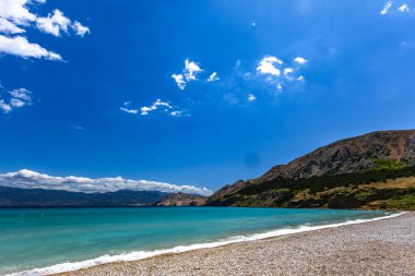 KRK adasındaki Baska 'daki boş çakıl taşı plajı, tatil sezonundan önce Hırvatistan' ın Adriyatik Denizi 'nde masmavi su