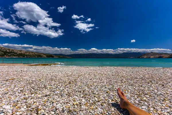 KR adasındaki Baska 'da boş bir plajda dinlenen bir kadın.