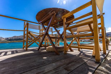 Hırvatistan 'ın Baska kentindeki Adriyatik Denizi' nde KR adasındaki bir restoranın verandasında tahta masa ve sandalyeler