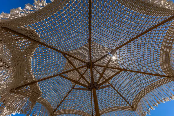 Hırvatistan 'ın KRK adasındaki Adriyatik Denizi kıyısındaki bir meyhanenin verandasında saman şemsiyesi altında sabah kahvesi içmek