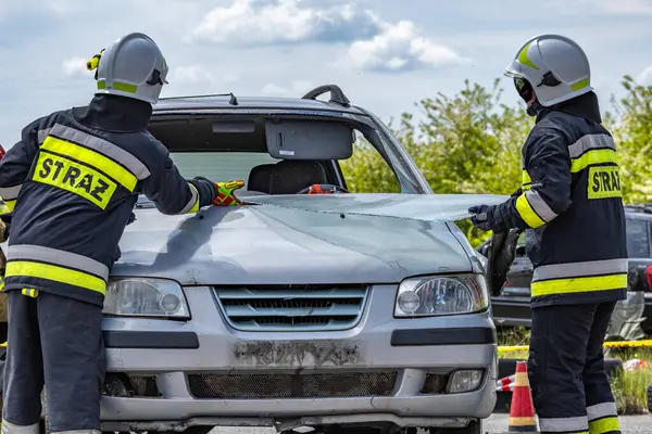 Kurtarma ekibinden bir itfaiyeci bir arabanın ön camını kesti. Araba kazasının olduğu yerde kurtarma operasyonu düzenlemek için özel aletler.