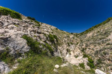 KRK adasındaki Baska 'dan Vela Luka plajına yürüyüş yolu, Vrzenica Pulu Vadisi' ni geçmek.
