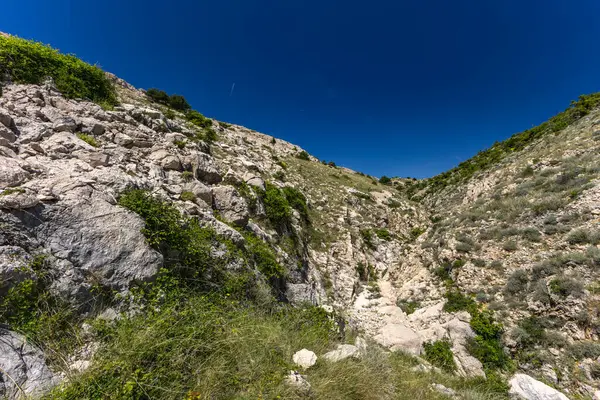 KRK adasındaki Baska 'dan Vela Luka plajına yürüyüş yolu, Vrzenica Pulu Vadisi' ni geçmek.