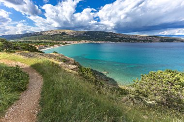 Açıklıkta yeşil çimenler, Baska kasabası yakınlarındaki bir patikada dinlenme, körfez ve şehir manzarası