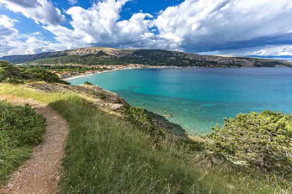 Açıklıkta yeşil çimenler, Baska kasabası yakınlarındaki bir patikada dinlenme, körfez ve şehir manzarası