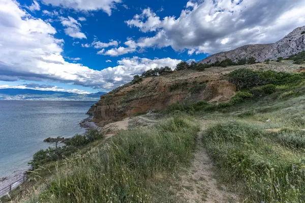 Açıklıkta yeşil çimenler, Baska kasabası yakınlarındaki bir patikada dinlenme, körfez ve şehir manzarası
