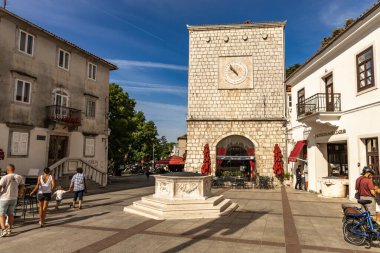 Croati 'deki KRK adasındaki şehir merkezindeki Vela Placa' da güneş saati olan kare kule.