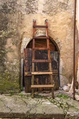 KRK adasında, Vrbnik 'in dar sokaklarında yürüyen eski bir ahşap merdiven, taş bir heykele yaslanır.