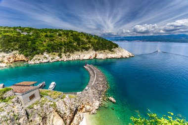Vrbnik kasabasının manzarası ve yüksek kayaların arasında küçük gizli bir plaj, KR adasındaki gizli çakıl taşı plajı.