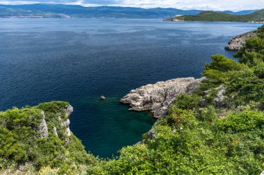 Vrbnik kasabası yakınlarındaki Pebbly Beach Kozica, Adriyatik Denizi kıyısındaki koyu masmavi su, Croati 'deki turizm sezonundan önce insanların olmadığı bir plaj.