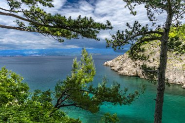 Vrbnik kasabası yakınlarındaki Pebbly Beach Kozica, Adriyatik Denizi kıyısındaki koyu masmavi su, Croati 'deki turizm sezonundan önce insanların olmadığı bir plaj.