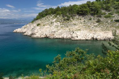 Vrbnik kasabası yakınlarındaki Pebbly Beach Kozica, Adriyatik Denizi kıyısındaki koyu masmavi su, Croati 'deki turizm sezonundan önce insanların olmadığı bir plaj.