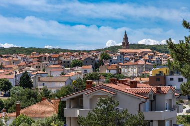 Hırvatistan 'ın KRK kentindeki Vrbnik kentinin panoramik manzarası, kırmızı çatılar ve şehrin üzerindeki eski çan kulesinin kulesi