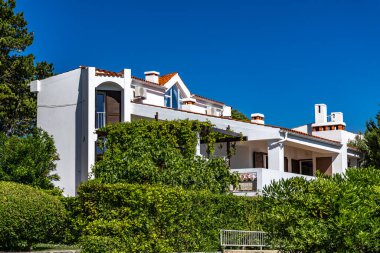 Adriyatik Denizi kıyısındaki Baska köyü boyunca yürüyüş güzergahı, resimli evler ve daireler, gök mavisi su