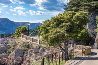 Adriyatik Denizi kıyısındaki Baska köyü boyunca yürüyüş güzergahı, resimli evler ve daireler, gök mavisi su