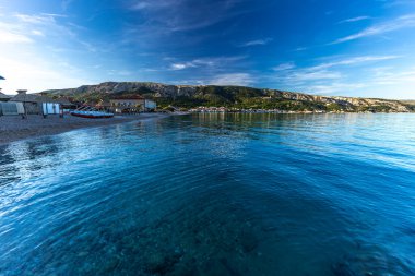 Adriyatik Denizi 'ne çakıl taşı plajından direk olarak engelliler için beton bir rampa ve güvenlik rayı ile giriliyor.