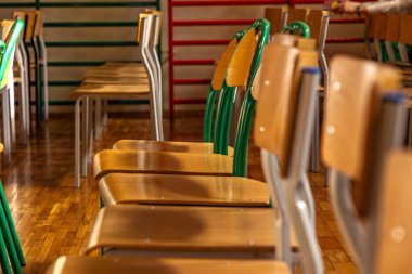 Spor salonundaki sandalyeler, okul yılı sonu, mezuniyet töreni, sınıfta boş sandalyeler.