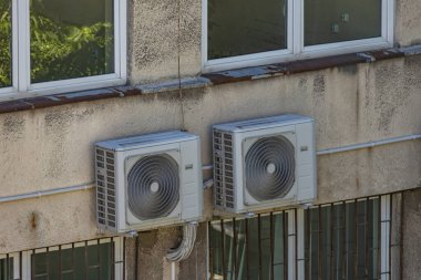 Kamu hizmetleri binasının dış duvarında bakım ve mantar ilacı gerektiren eski hasarlı klimalar, havalandırma arızası.