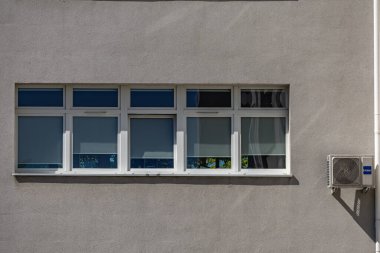 Kamu hizmetleri binasının dış duvarında bakım ve mantar ilacı gerektiren eski hasarlı klimalar, havalandırma arızası.