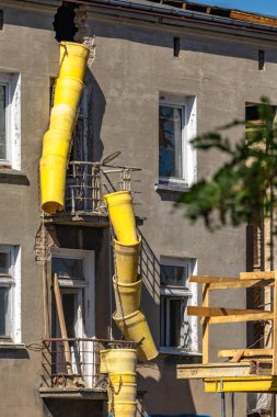 Bir binadan moloz atmak için sarı boru, şehir merkezindeki eski bir apartmanın yenilenmesi, dikkat - tehlikeli plaka