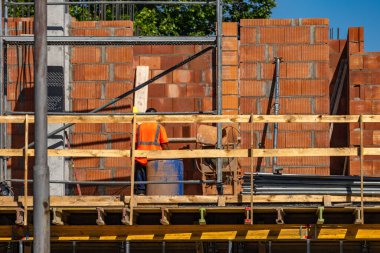 Şehir merkezinde yeni bir apartman inşaatı, kırmızı tuğla duvar, ahşap iskele.