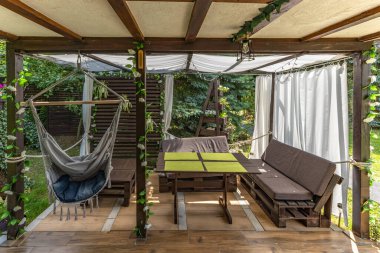 Sallanan hamak, verandada asılı gri Brezilya sandalyesi ahşap pergola, bahçede dinlenmek için bir yer.