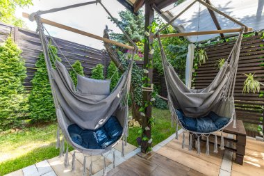 Sallanan hamak, verandada asılı gri Brezilya sandalyesi ahşap pergola, bahçede dinlenmek için bir yer.